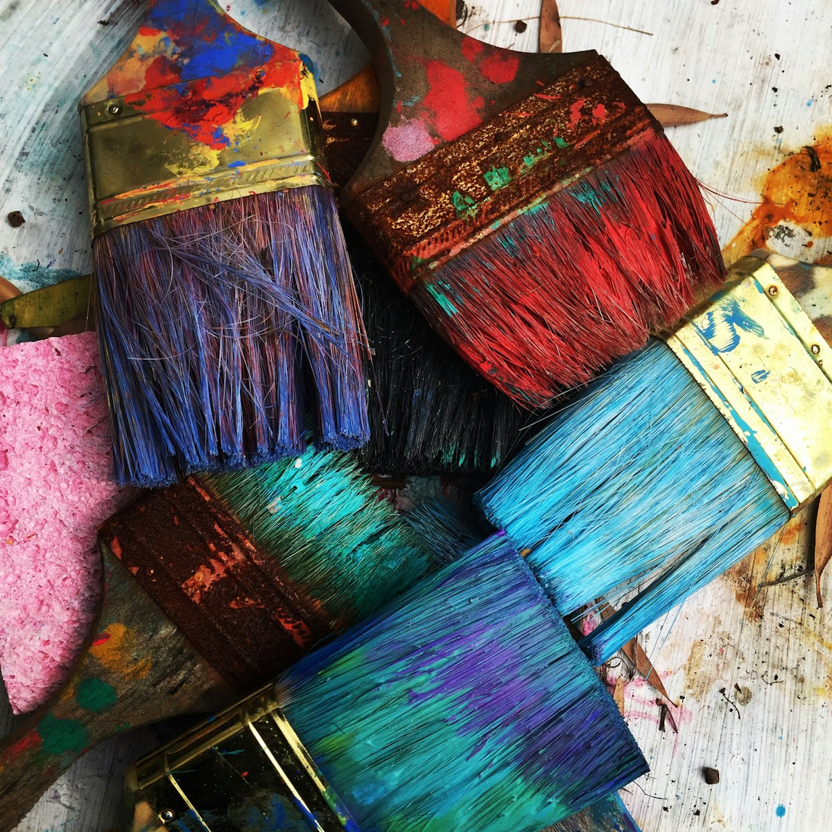 A collection of brushes covered in colorful paint